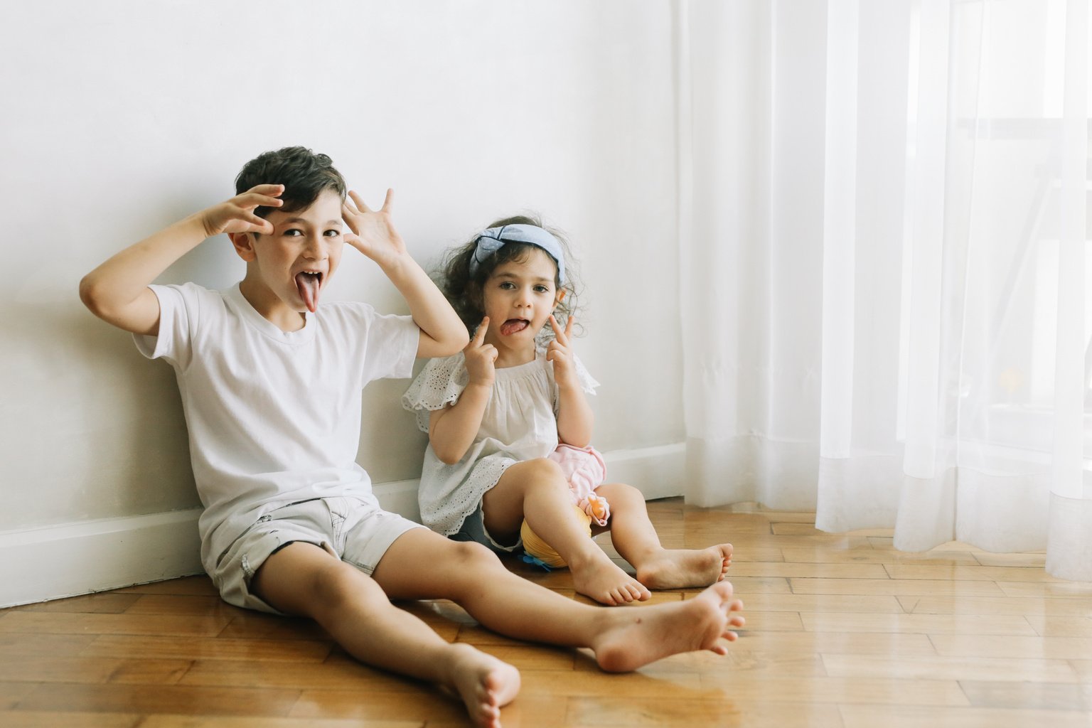 Children Sitting on the Floor and Making Funny Faces