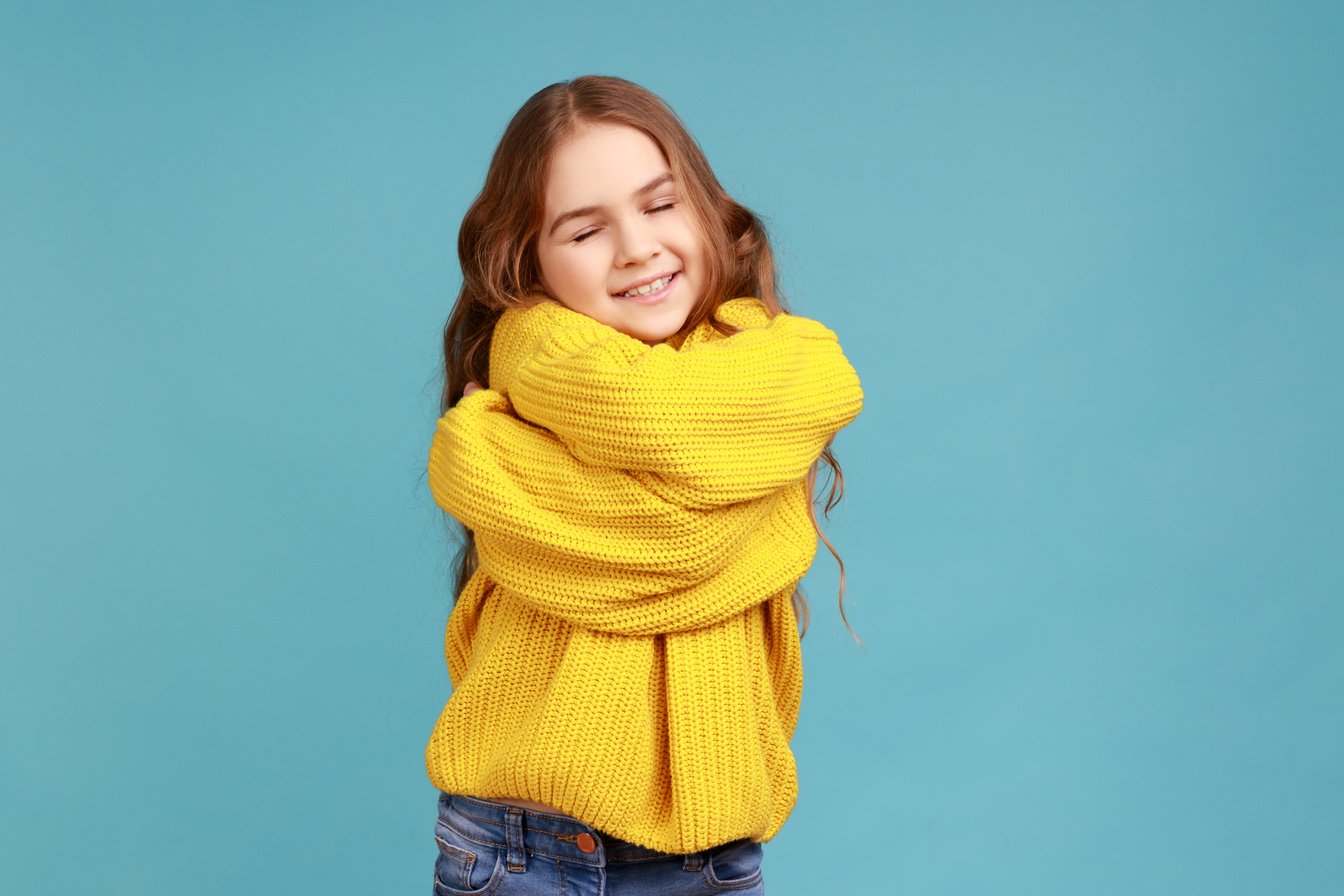 Portrait of Charming Little Girl Embracing Herself and Smiling from Happiness, Positive Self-Esteem.